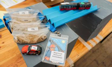 Sandsäcke, Spielzeugautos und eine Papierbrücke