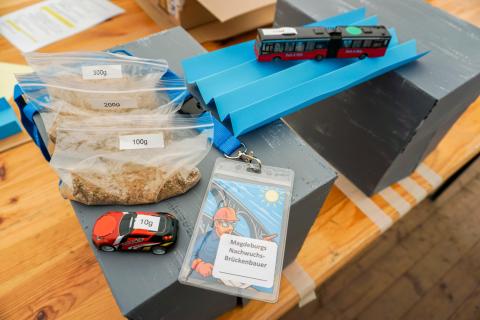 Sandsäcke, Spielzeugautos und eine Papierbrücke